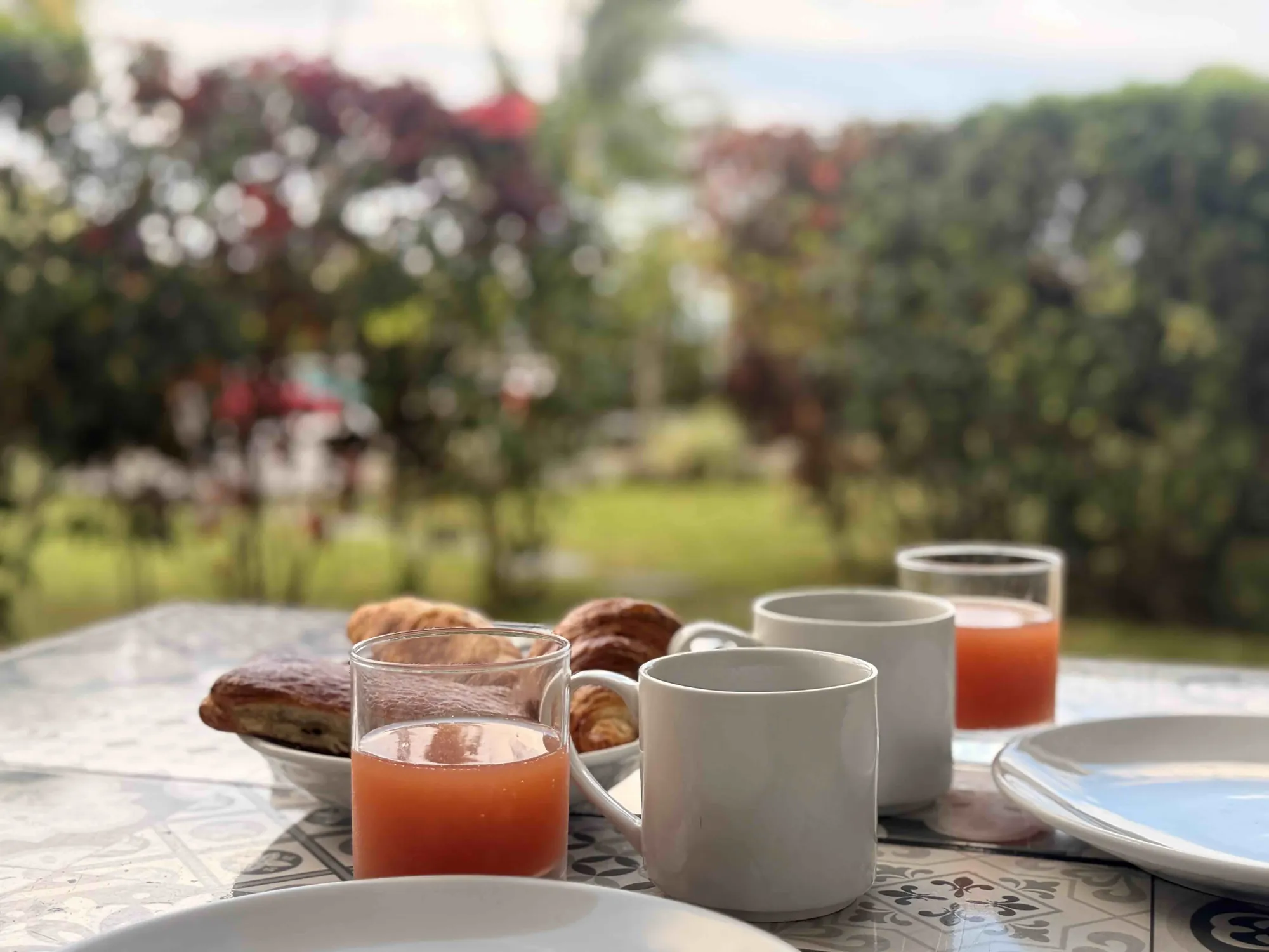 Petit-déjeuner avec jus de fruits et viennoiseries en terrasse du Cook's Bay Hotel & Suites, Moorea