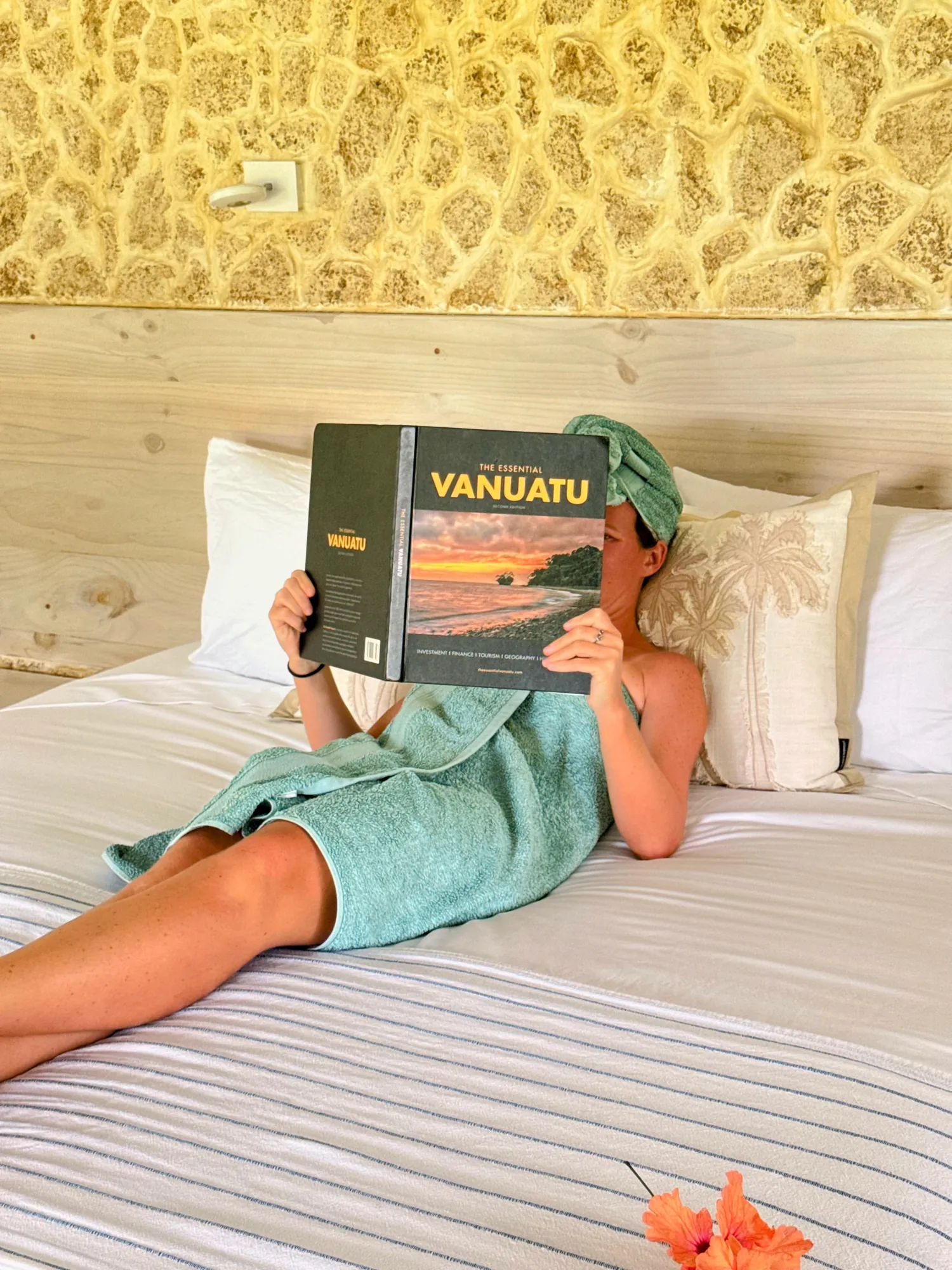 Femme lisant un livre sur le Vanuatu allongée sur le lit de la villa Santo Saffire